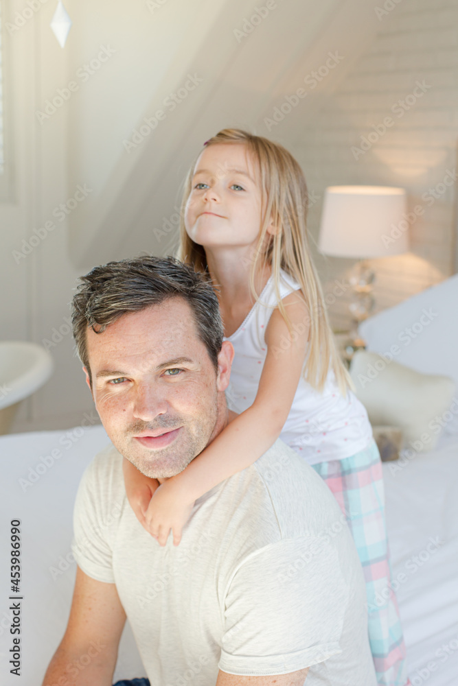 Father and daughter hugging on bed