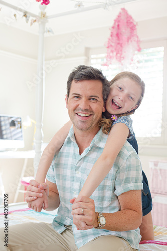 Father and daughter hugging in bedroom