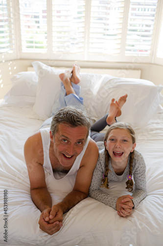 Father and daughter laying on bed