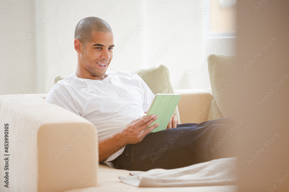 Man using digital tablet on sofa
