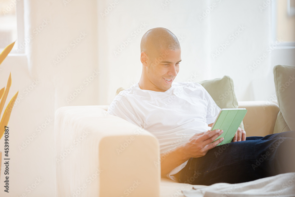 Man using digital tablet on sofa Man using digital tablet on sofa