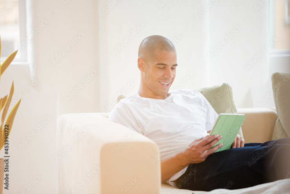 Man using digital tablet on sofa