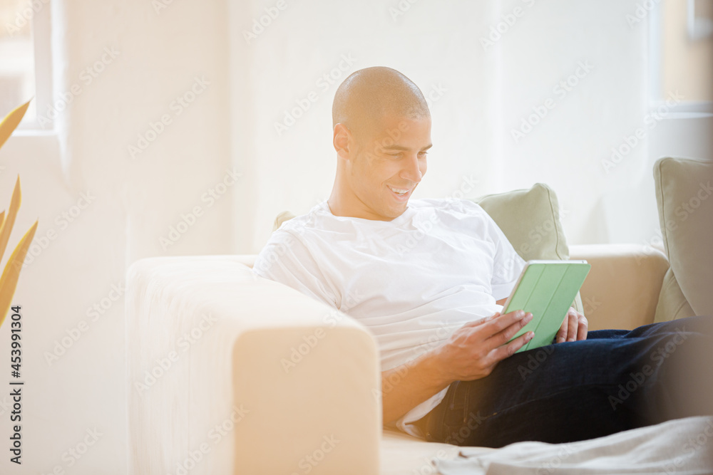Man using digital tablet on sofa Man using digital tablet on sofa