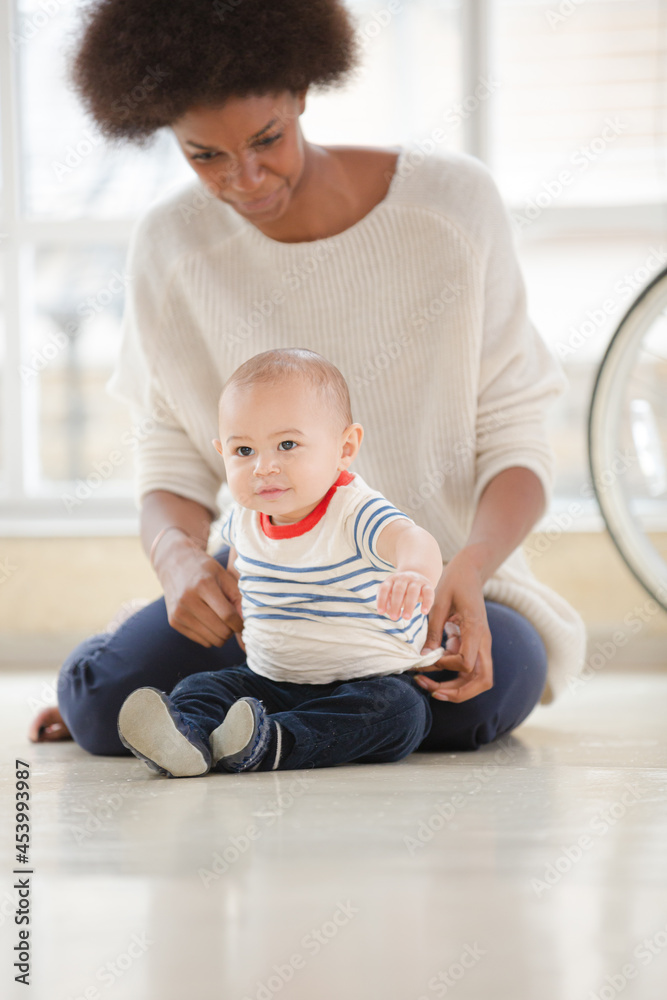 Mother holding baby boy on floor Mother holding baby boy on floor