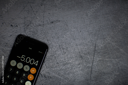 phone placed in a desk, with application calculator open, negative accounting