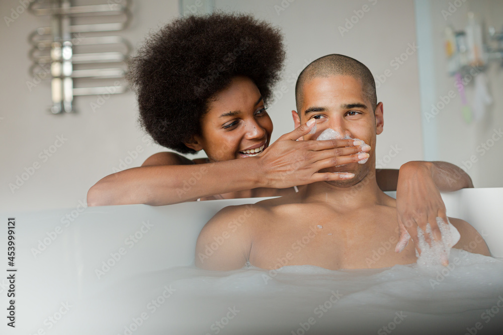 Woman playing with boyfriend in bubble bath Woman playing with boyfriend in bubble bath