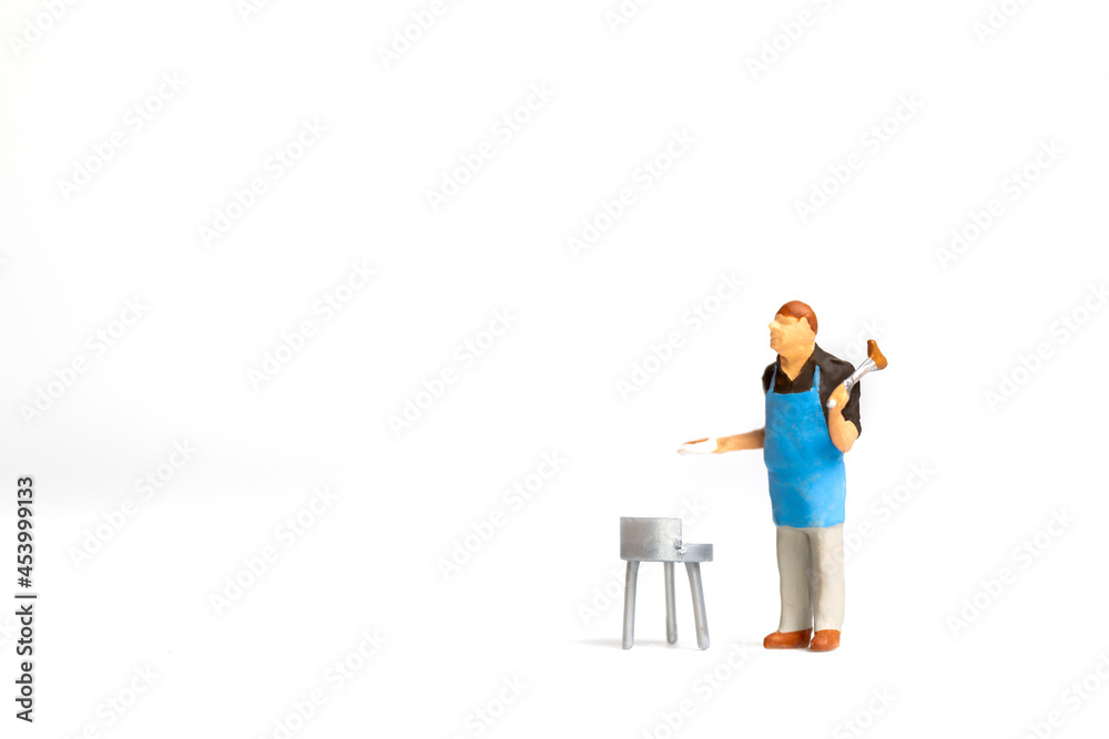 Miniature people ,Chef cooking steak on barbecue grill isolated on white background Miniature people ,Chef cooking steak on barbecue grill isolated on white background