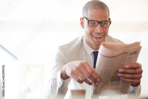 Businessman reading newspaper and drinking coffee