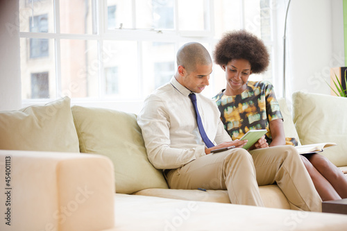 Business people using digital tablet on sofa