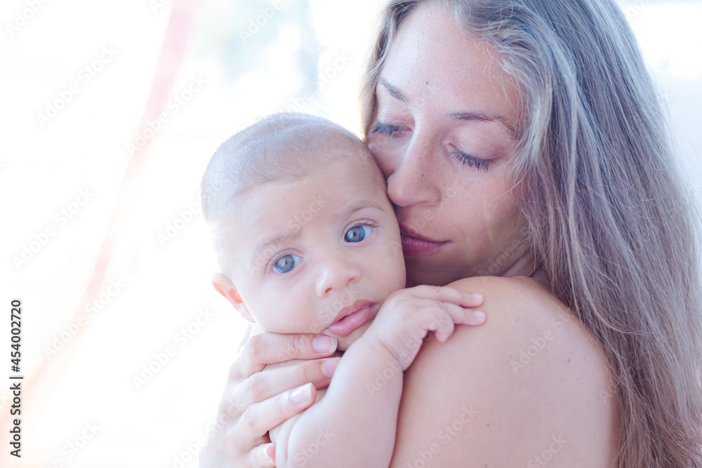 Bare chested mother holding baby boy Bare chested mother holding baby boy
