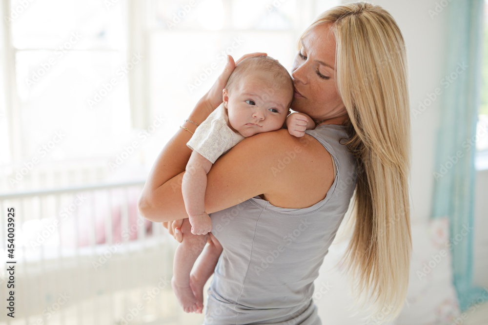 Mother holding baby girl in nursery Mother holding baby girl in nursery