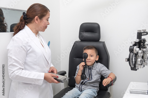 .Preventive health. Early detection of visual problems in children. Child performs vision test in office in front of an ophthalmologist