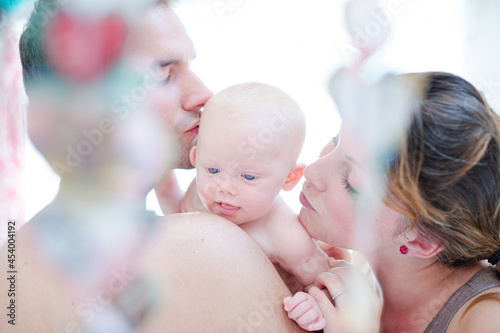 Parents kissing baby girl's cheeks