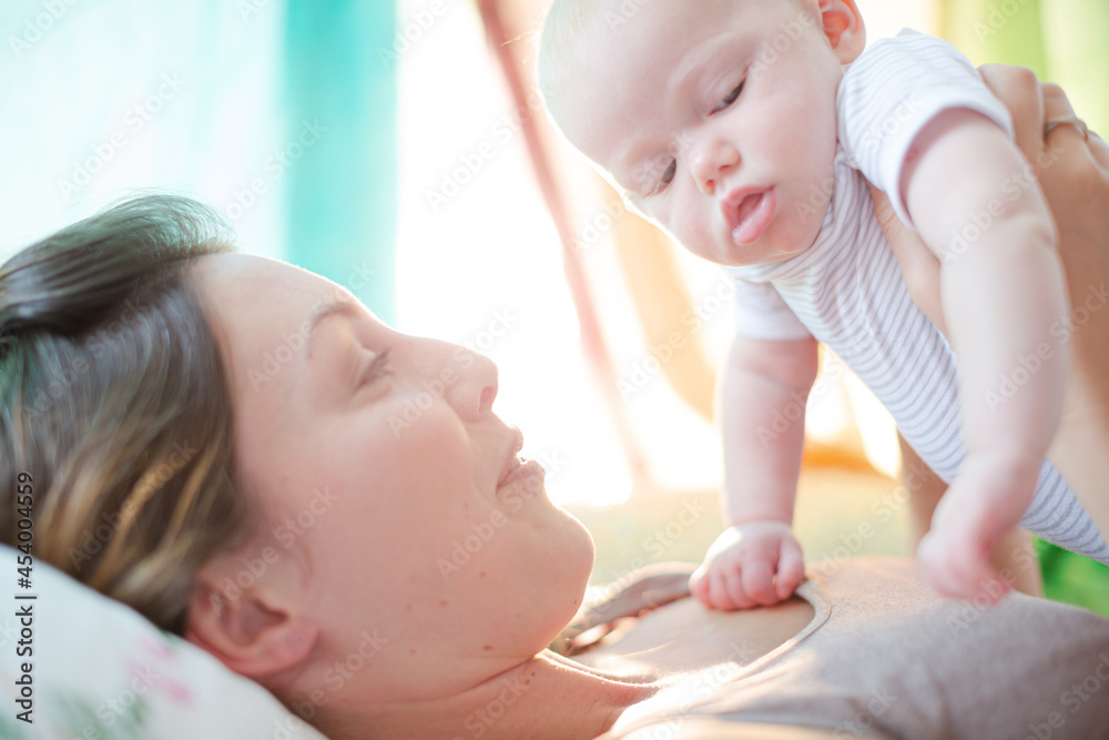 Mother holding baby girl on bed Mother holding baby girl on bed
