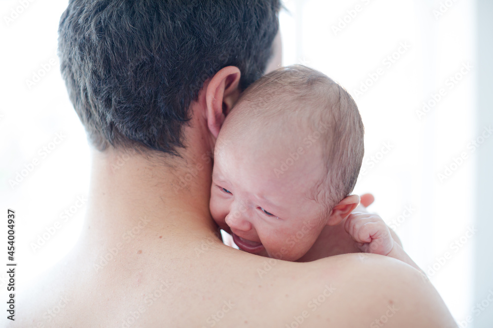 Man comforting crying baby girl Man comforting crying baby girl