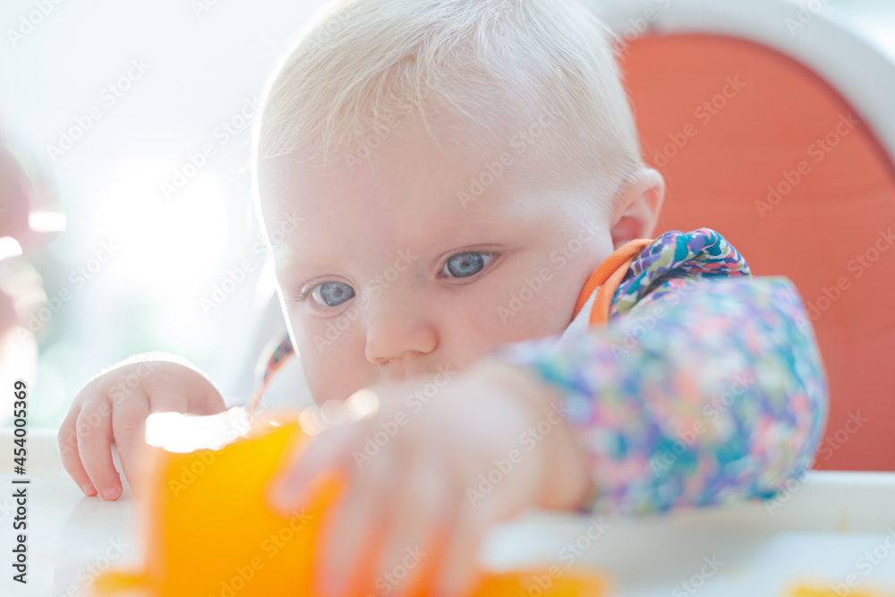 Baby girl playing with gelatin dessert in high chair Baby girl playing with gelatin dessert in high chair