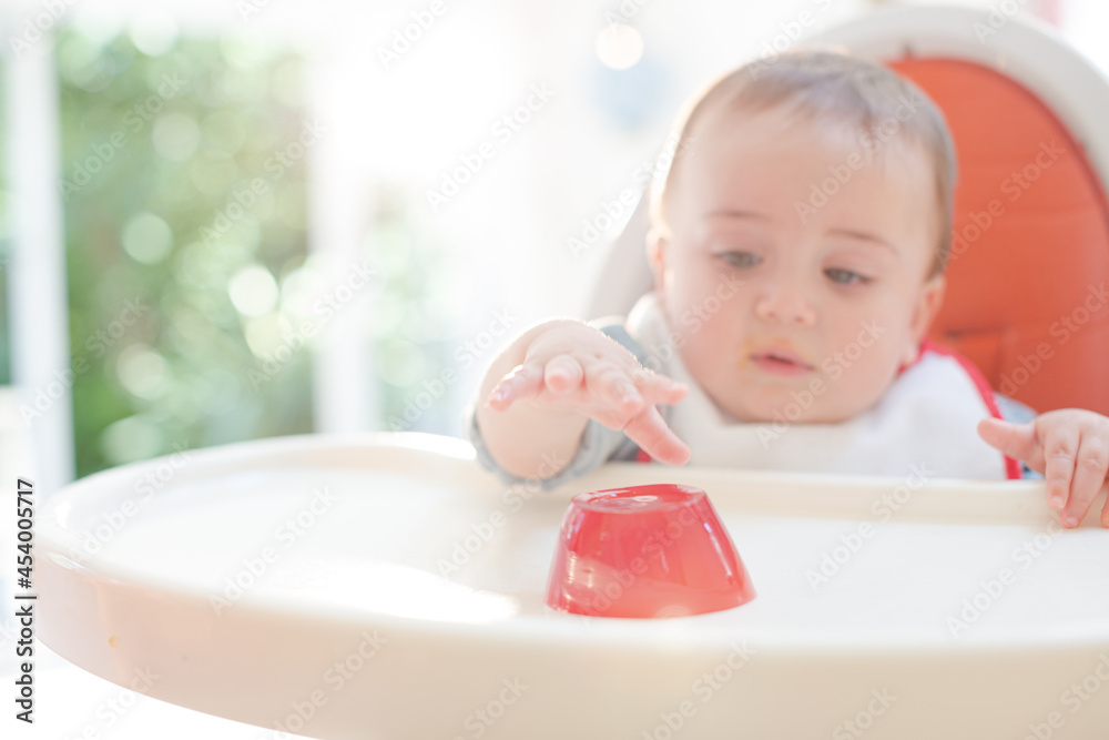 Baby boy eating gelatin dessert in high chair Baby boy eating gelatin dessert in high chair
