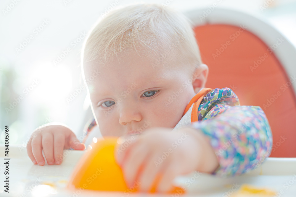 Baby girl playing with gelatin dessert in high chair Baby girl playing with gelatin dessert in high chair