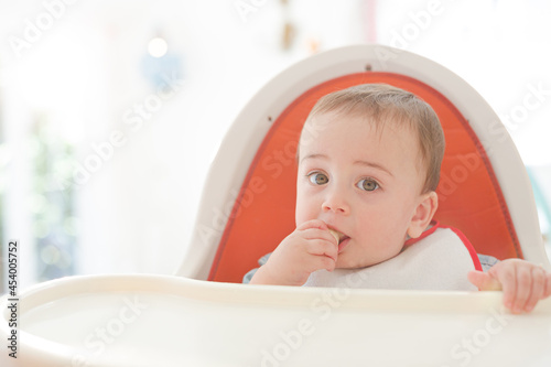 Baby girl eating in high chair