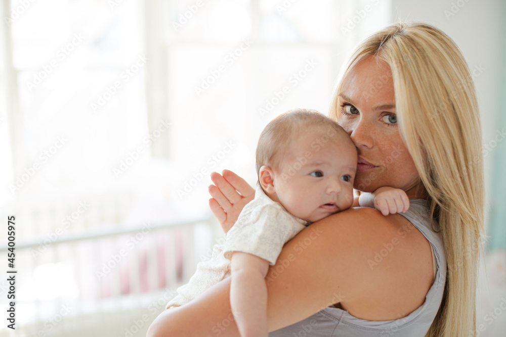 Mother holding baby girl in nursery Mother holding baby girl in nursery