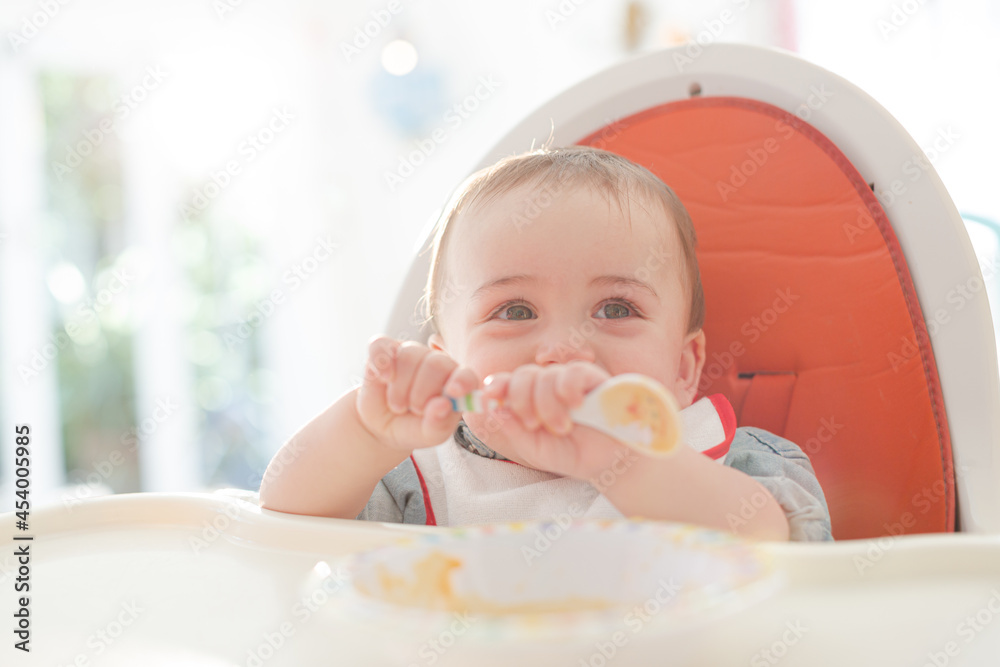 Baby boy eating in high chair Baby boy eating in high chair