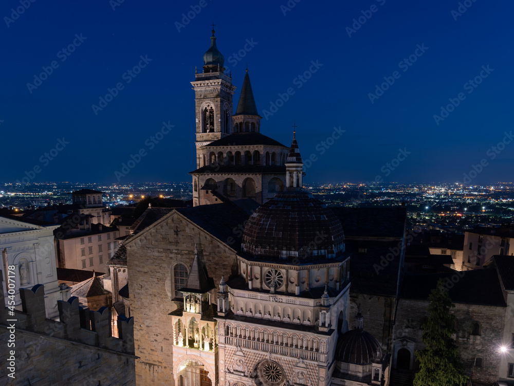 Bergamo, Italy. The old town. Amazing aerial view of the Basilica of Santa Maria Maggiore during the night. In the background the Po plain. Bergamo best of Italy