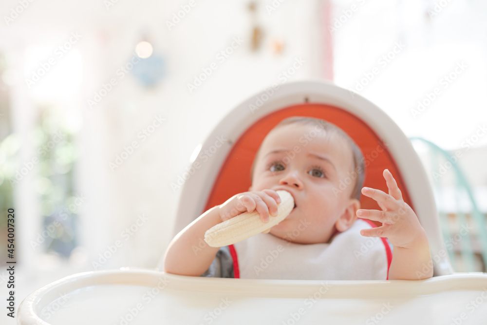 Baby girl eating in high chair Baby girl eating in high chair