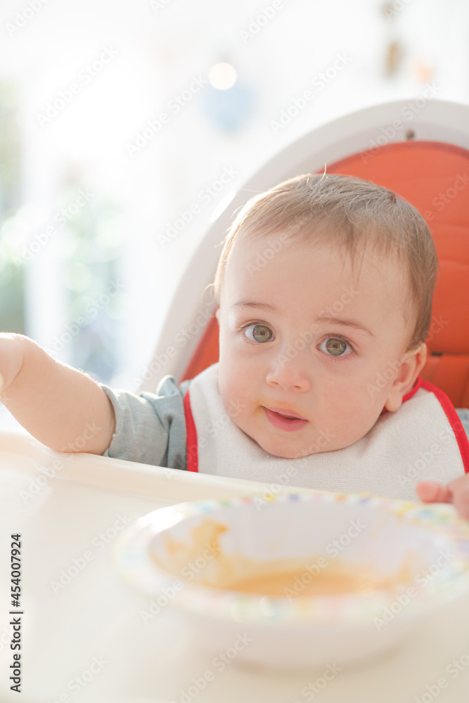 Baby boy eating in high chair Baby boy eating in high chair