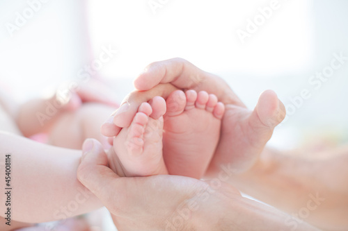 Father cradling baby boy's feet © KOTO