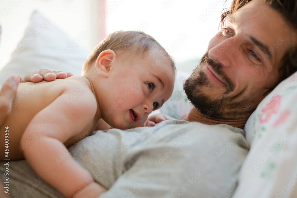 Father laying with baby boy on bed Father laying with baby boy on bed