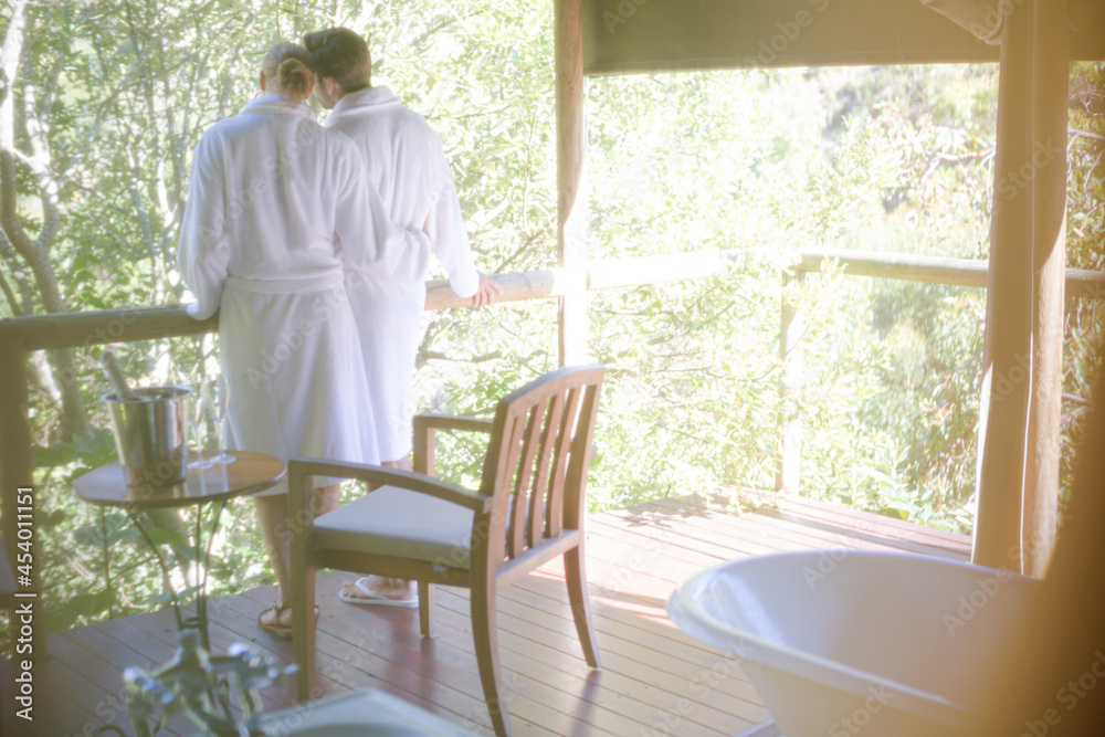 Couple in bathrobes standing on balcony Couple in bathrobes standing on balcony