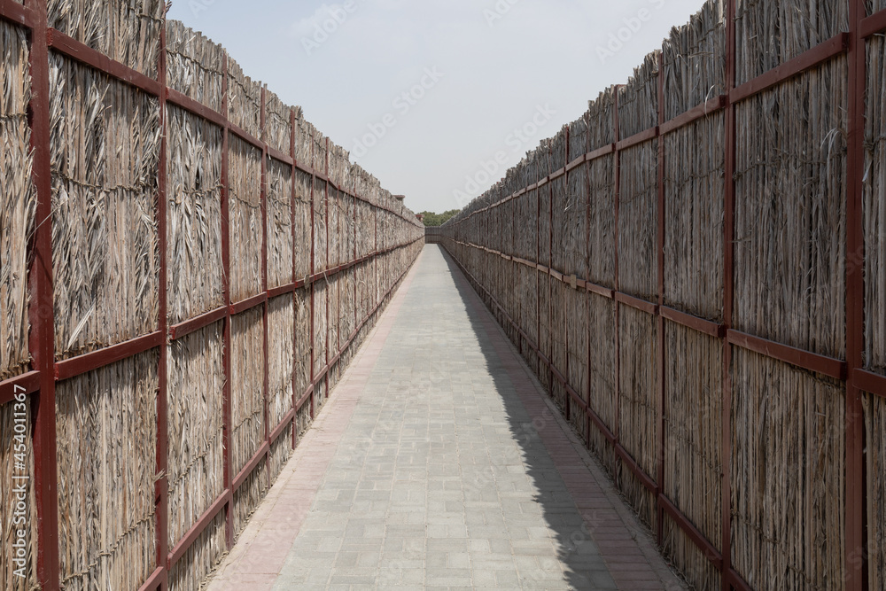 The pass between two straw walls on sunny day The pass between two straw walls on sunny day