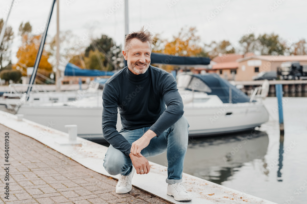 Fit healthy trendy senior man at a marina with yachts Fit healthy trendy senior man at a marina with yachts
