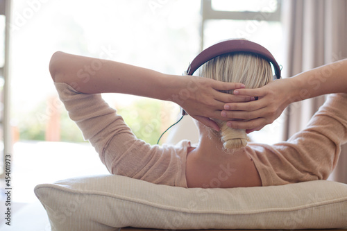 Woman listening to headphones on sofa