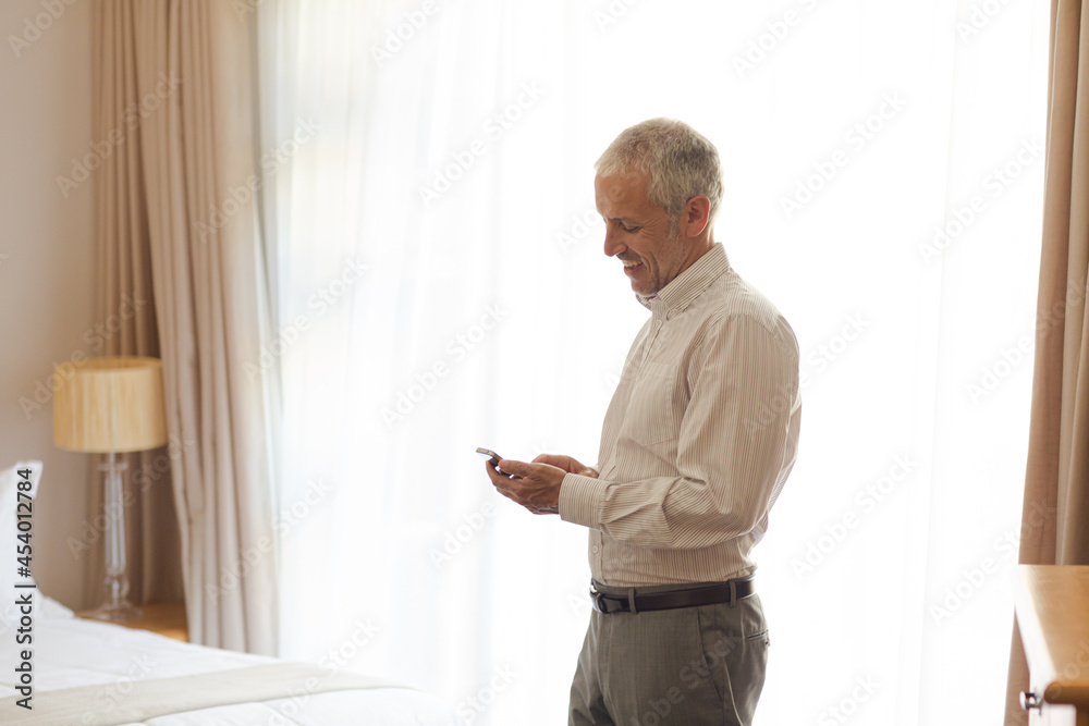 Businessman using cell phone in hotel room Businessman using cell phone in hotel room