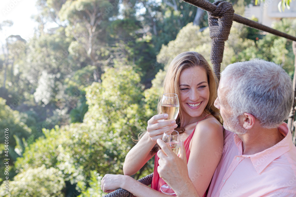 Obraz premium Couple toasting each other on wooden rope bridge