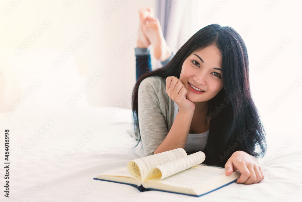 Young beautiful woman reading a book on bed at home, education, reading for examination, favourite literature, busy day concept Young beautiful woman reading a book on bed at home, education, reading for examination, favourite literature, busy day concept