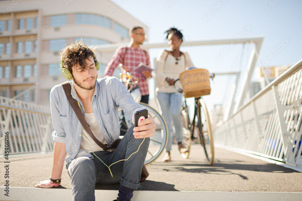 Man listening to headphones on city street