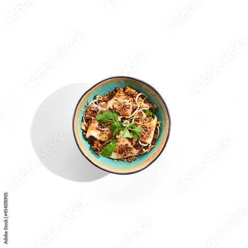 Pan asian traditional dish - fried rice with egg, vegetables, and squid. Indian wok with rice, egg and kalmar on white background. Nasi goreng with calamari on isolated background with shadows.
