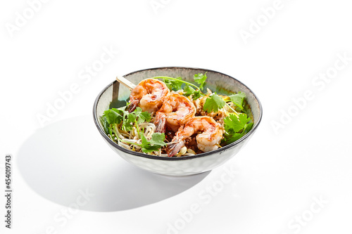 Chinese traditional dish - fried rice with egg, vegetables, and prawn. Pan asian wok with rice and shrimp on white background. Nasi goreng with prawns on isolated background with shadows.