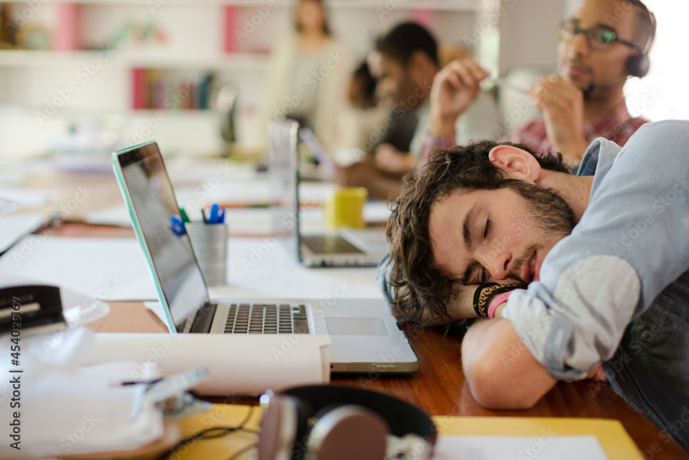 Man sleeping at desk in office Man sleeping at desk in office