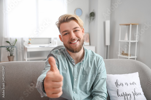 Young man showing thumb-up ...