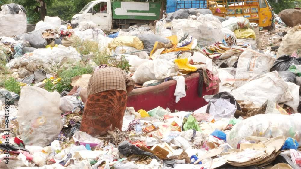 View of woman rag picker collecting recyclable products View of woman rag picker collecting recyclable products
