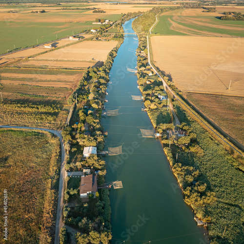 Photos Aerial view of fishing huts on river with typical italian fishing machine, called trabucco,Lido di Dante, fiumi uniti Ravenna near Comacchio valley