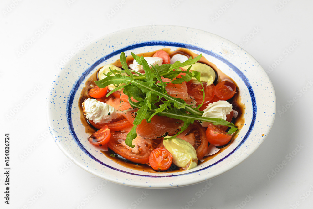 Tomato and salmon salad with cheese and spices. Traditional Italian cuisine, Italian concept. Tomato and salmon salad with cheese and spices. Traditional Italian cuisine, Italian concept.