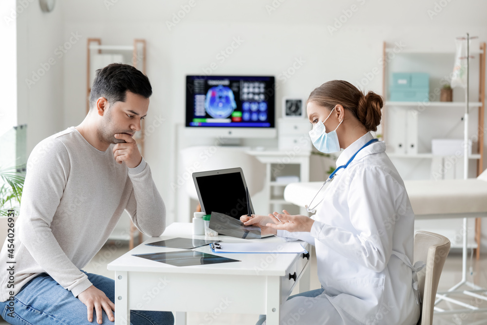 Young doctor working with patient in clinic