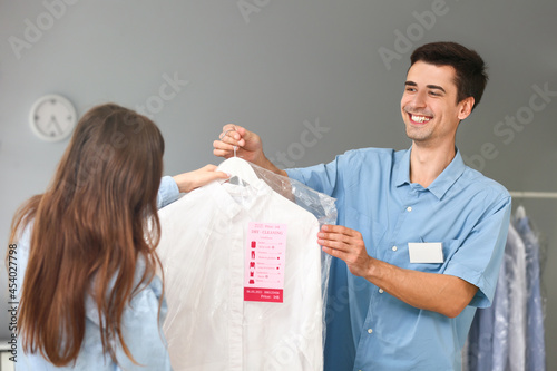Worker giving clothes to cl...