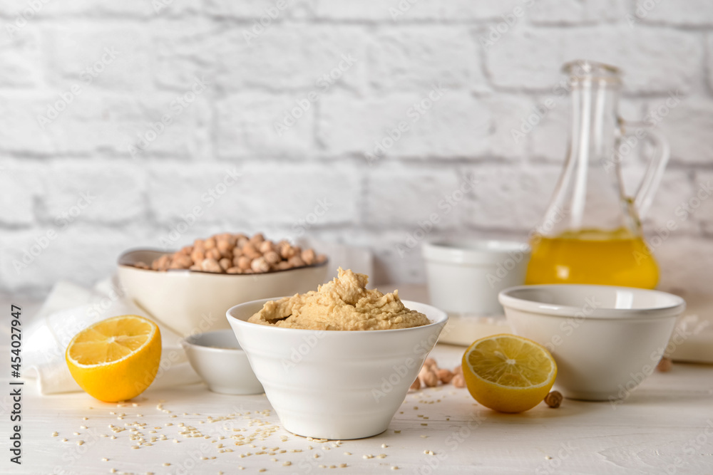 Bowl with tasty hummus and lemon on table Bowl with tasty hummus and lemon on table
