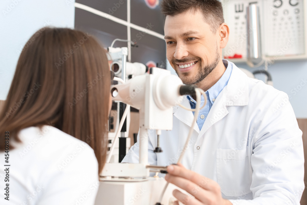 Ophthalmologist examining young woman in clinic