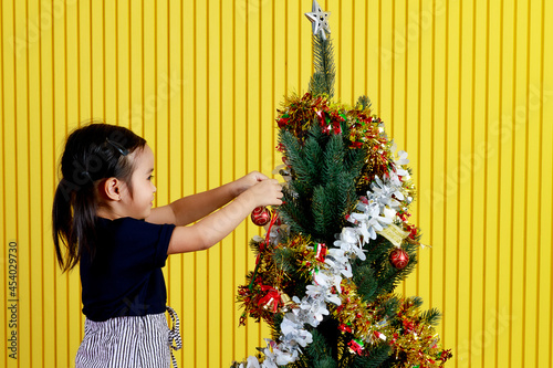 Little girl and Christmas tree photo